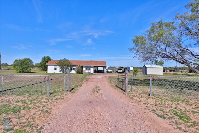 view of front facade with an outbuilding, a rural view, and a carport