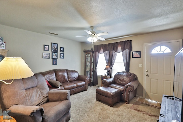 living room with light carpet, a textured ceiling, and ceiling fan