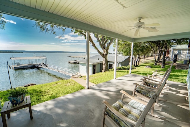 view of patio / terrace featuring a boat dock, a water view, and ceiling fan