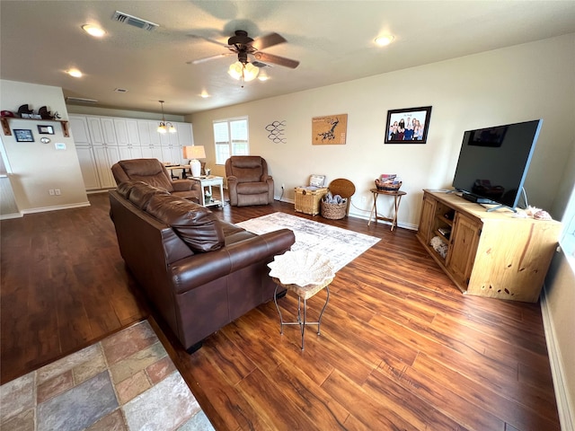 living room with ceiling fan with notable chandelier and hardwood / wood-style flooring