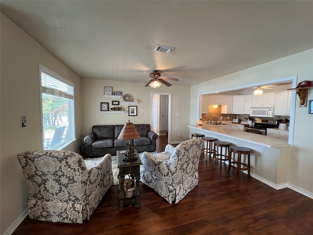 living room with ceiling fan, dark wood-type flooring, and sink