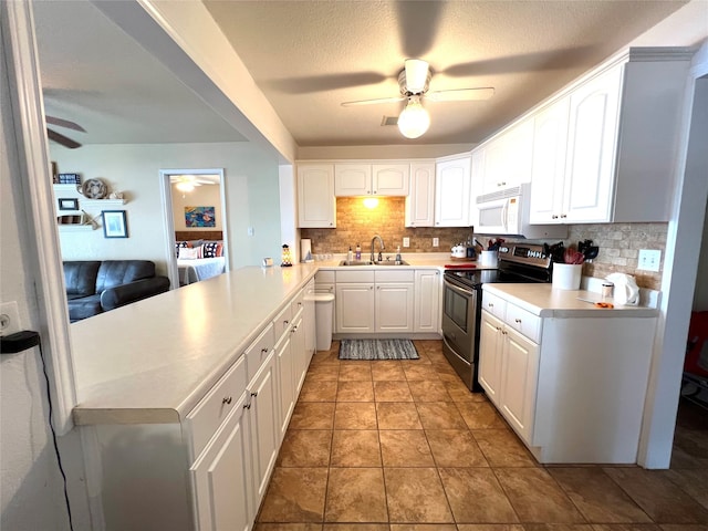 kitchen with sink, kitchen peninsula, stainless steel range with electric stovetop, decorative backsplash, and white cabinets