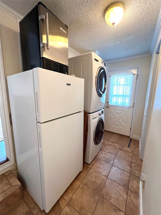 laundry room with light tile patterned floors, a textured ceiling, crown molding, and stacked washer and clothes dryer