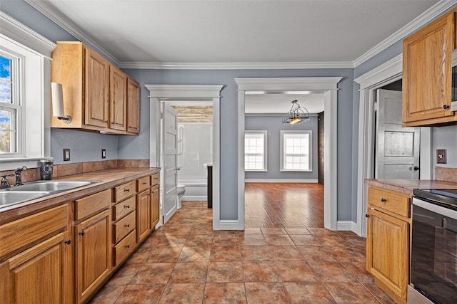 kitchen with pendant lighting, sink, crown molding, stainless steel electric range, and light tile patterned floors