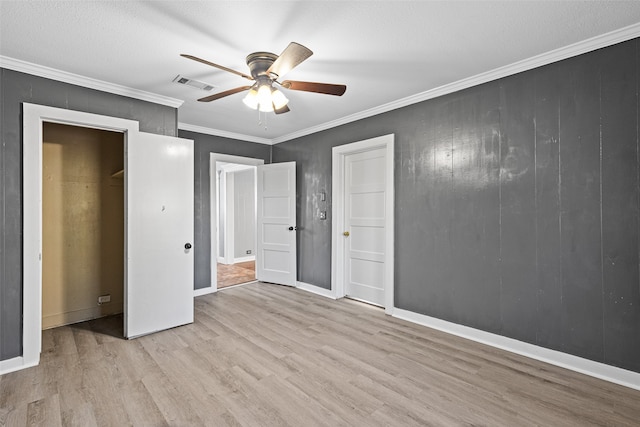 unfurnished bedroom with crown molding, ceiling fan, and light wood-type flooring