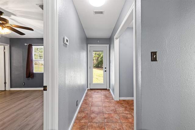 doorway featuring light tile patterned floors and ceiling fan