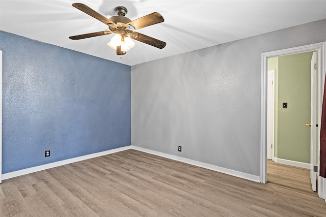 empty room with ceiling fan and light hardwood / wood-style floors