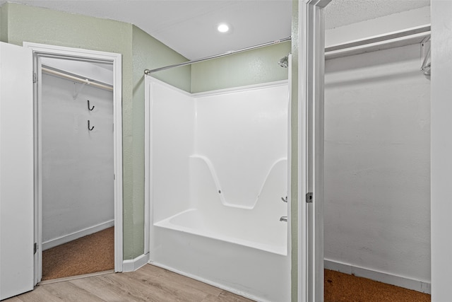 bathroom with hardwood / wood-style flooring and bathtub / shower combination