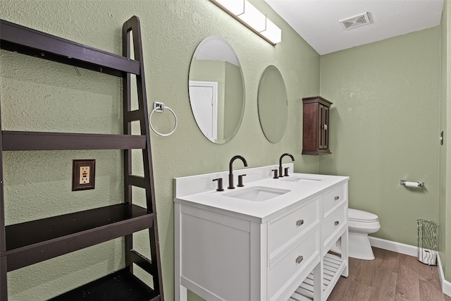 bathroom featuring vanity, hardwood / wood-style flooring, and toilet