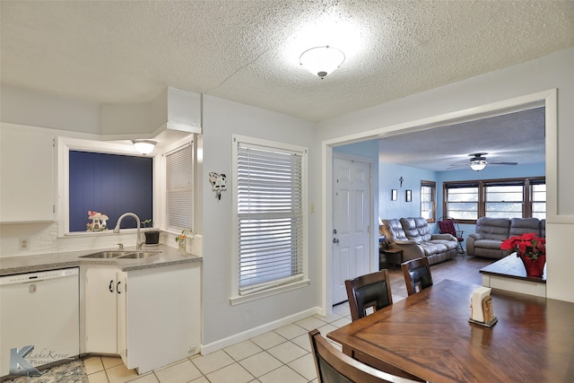 tiled dining space featuring ceiling fan, sink, and a textured ceiling