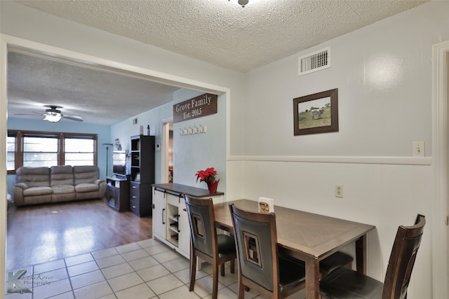 dining area with ceiling fan, a textured ceiling, and light wood-type flooring