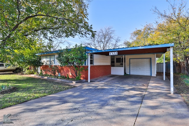 ranch-style home featuring a front lawn, a garage, and a carport