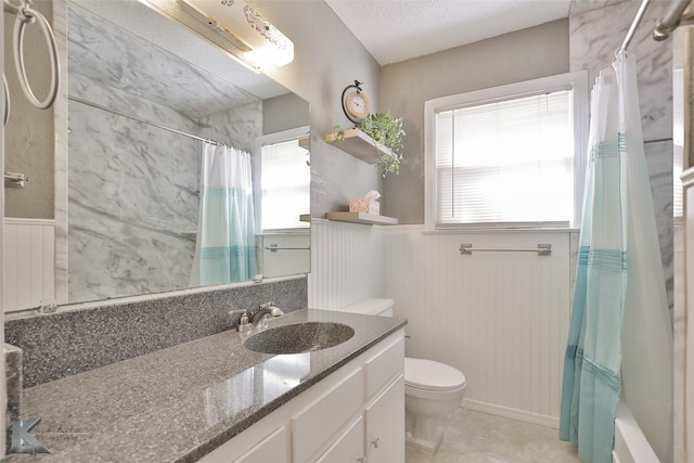 full bathroom featuring a textured ceiling, vanity, shower / tub combo with curtain, wooden walls, and toilet