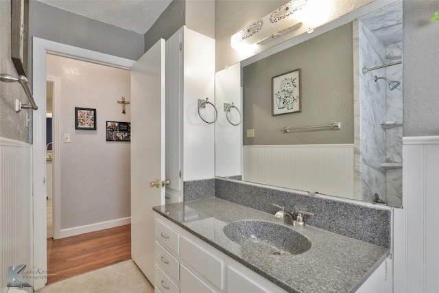 bathroom featuring vanity, wood-type flooring, and a textured ceiling