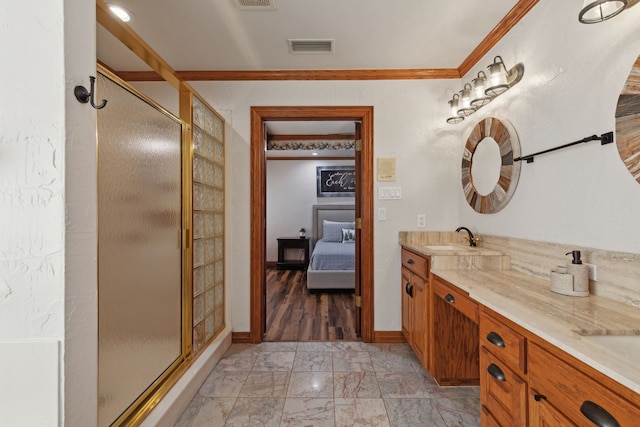 bathroom with vanity, a shower with door, and ornamental molding