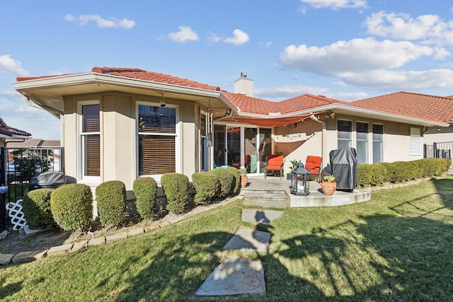 back of house featuring a patio and a lawn