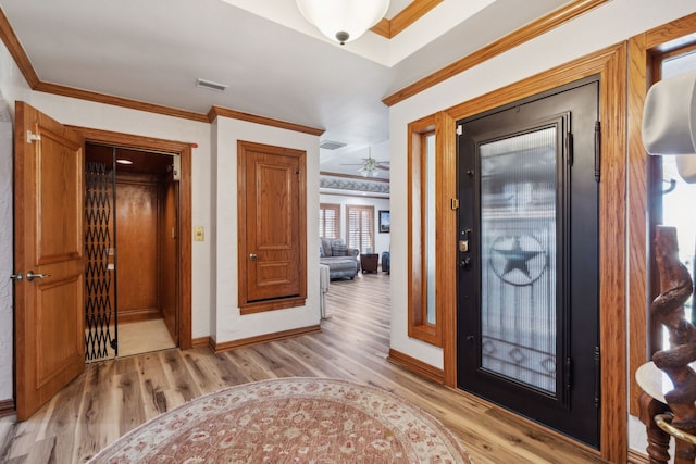 entryway featuring ceiling fan, light wood-type flooring, and crown molding