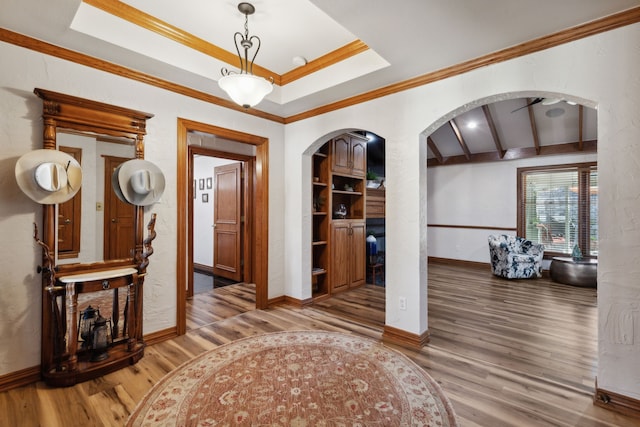 interior space featuring hardwood / wood-style floors, ceiling fan, crown molding, and beamed ceiling