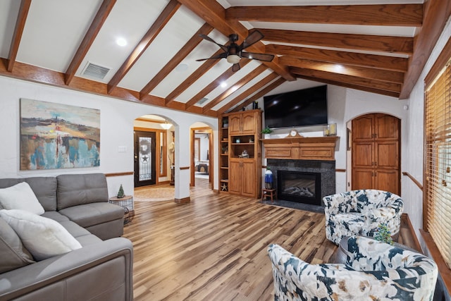 living room featuring a high end fireplace, ceiling fan, high vaulted ceiling, beamed ceiling, and light hardwood / wood-style floors