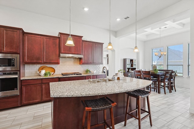 kitchen with an inviting chandelier, hanging light fixtures, decorative backsplash, appliances with stainless steel finishes, and beam ceiling