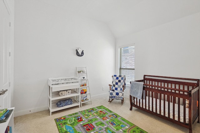 bedroom featuring carpet, vaulted ceiling, and a nursery area