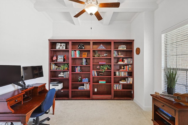 office space featuring ceiling fan, coffered ceiling, beamed ceiling, crown molding, and light colored carpet