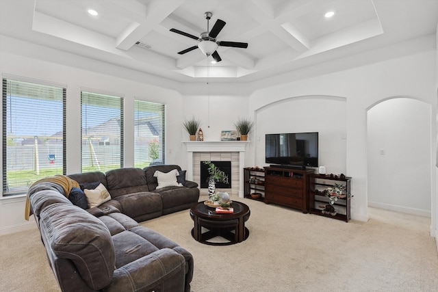 carpeted living room with a fireplace, beamed ceiling, ceiling fan, and coffered ceiling