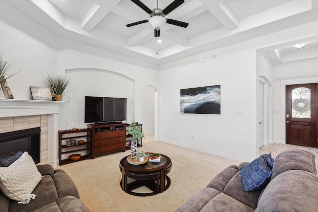 living room featuring light carpet, beamed ceiling, coffered ceiling, and a tiled fireplace