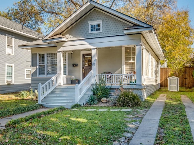 bungalow-style home featuring covered porch and a front lawn