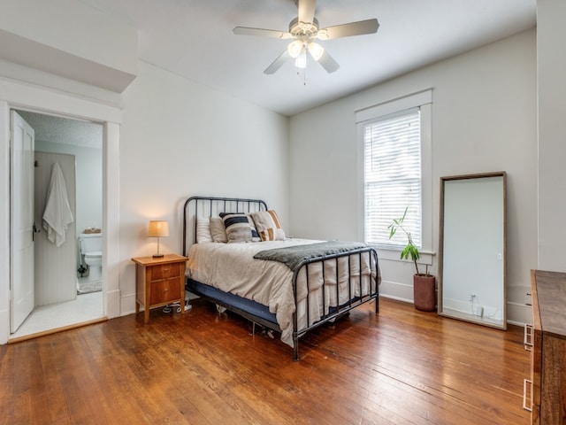 bedroom with ensuite bath, ceiling fan, and hardwood / wood-style floors