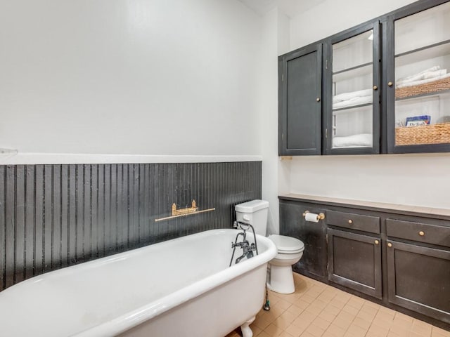 bathroom with tile patterned flooring, a tub, and toilet