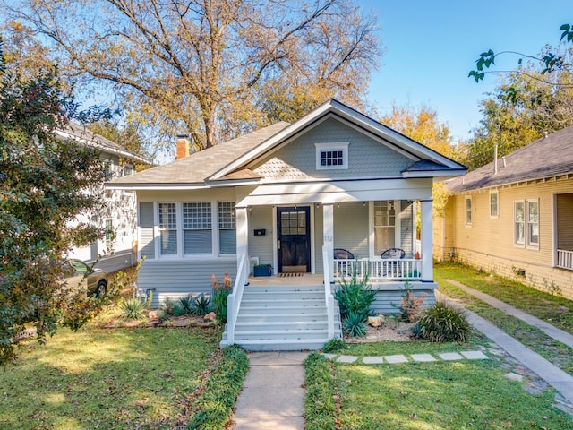 bungalow-style house with a front lawn and covered porch