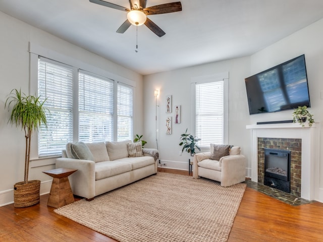 living room with a fireplace, hardwood / wood-style flooring, and ceiling fan