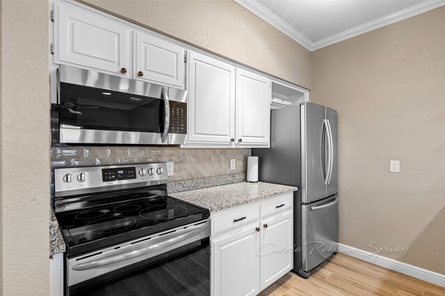 kitchen with backsplash, white cabinetry, and stainless steel appliances