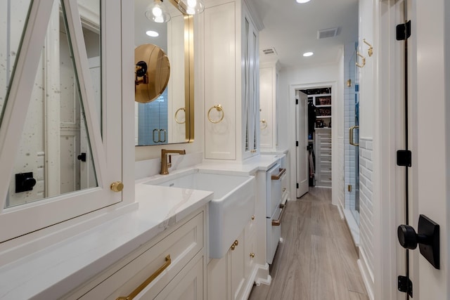 bathroom featuring vanity, a shower with shower door, and hardwood / wood-style floors