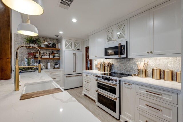 home office featuring beamed ceiling, plenty of natural light, a chandelier, and light hardwood / wood-style flooring