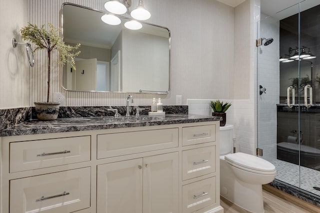 bathroom featuring vanity, a shower with shower door, and toilet