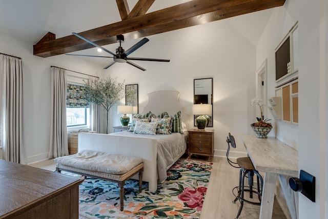 bedroom featuring vaulted ceiling with beams, ceiling fan, and light hardwood / wood-style flooring