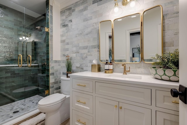 bathroom featuring tile walls, vanity, a shower with shower door, and toilet