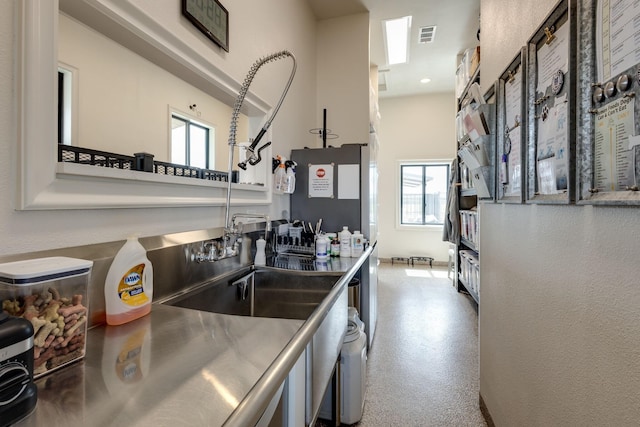 kitchen with stainless steel counters, fridge, and sink