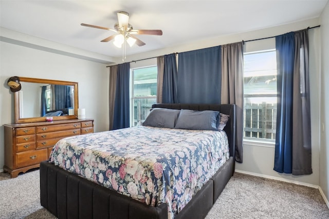 carpeted bedroom featuring multiple windows and ceiling fan