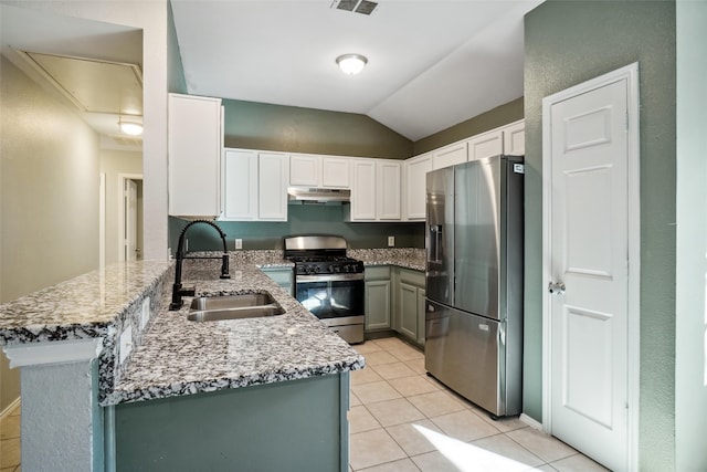 kitchen with sink, stainless steel appliances, kitchen peninsula, lofted ceiling, and light tile patterned floors