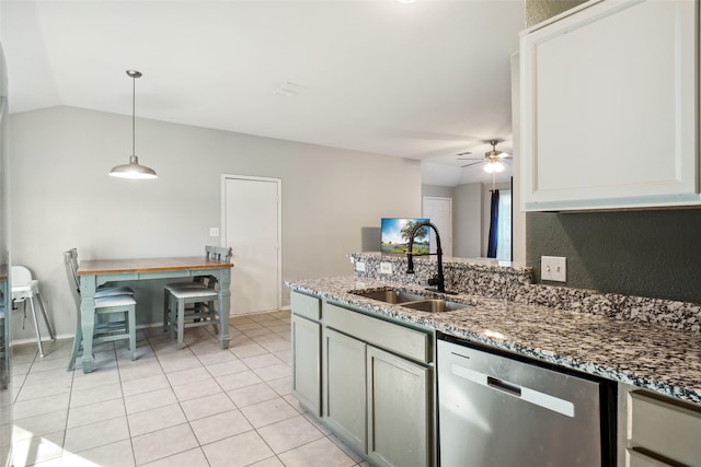 kitchen featuring dark stone counters, sink, decorative light fixtures, dishwasher, and lofted ceiling