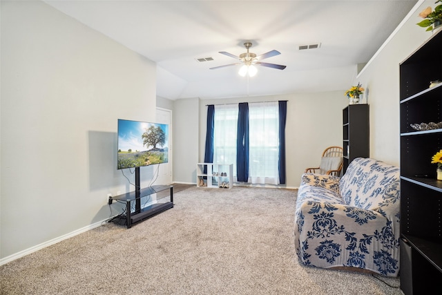 carpeted living room with ceiling fan and vaulted ceiling