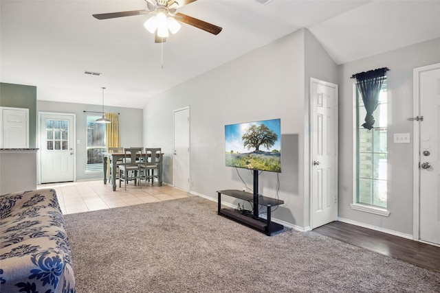 living room with vaulted ceiling, carpet, a wealth of natural light, and ceiling fan