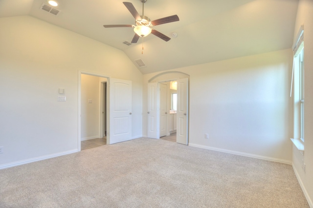 carpeted empty room with ceiling fan and vaulted ceiling