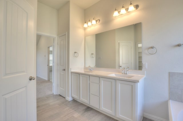 bathroom featuring hardwood / wood-style flooring, vanity, and a bathing tub