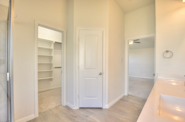 bathroom with ceiling fan, vanity, and wood-type flooring