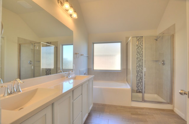 bathroom with separate shower and tub, hardwood / wood-style floors, vanity, and vaulted ceiling