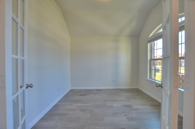 empty room featuring light wood-type flooring and lofted ceiling